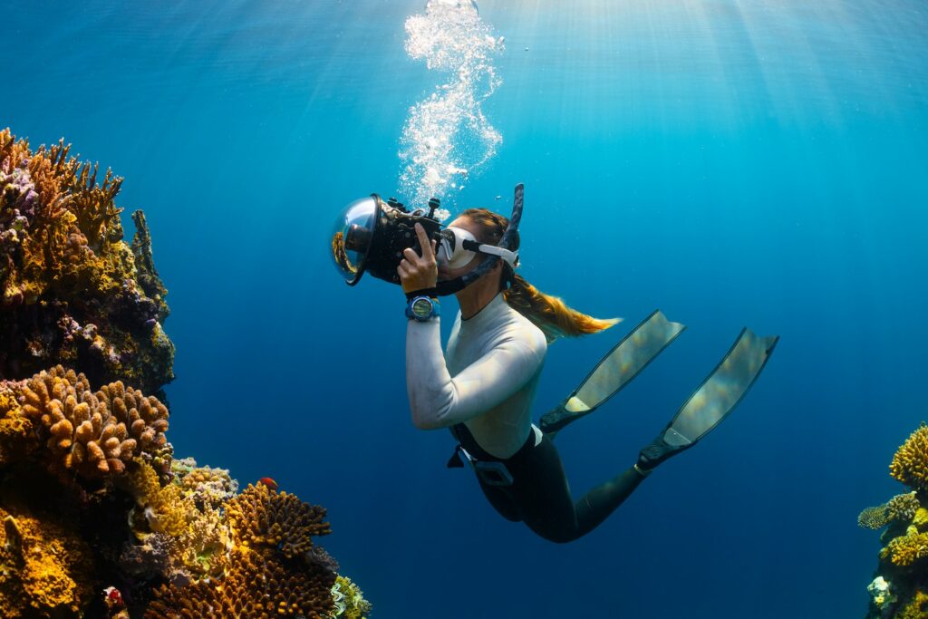 Underwater Cameras a woman scubas in the ocean with a camera