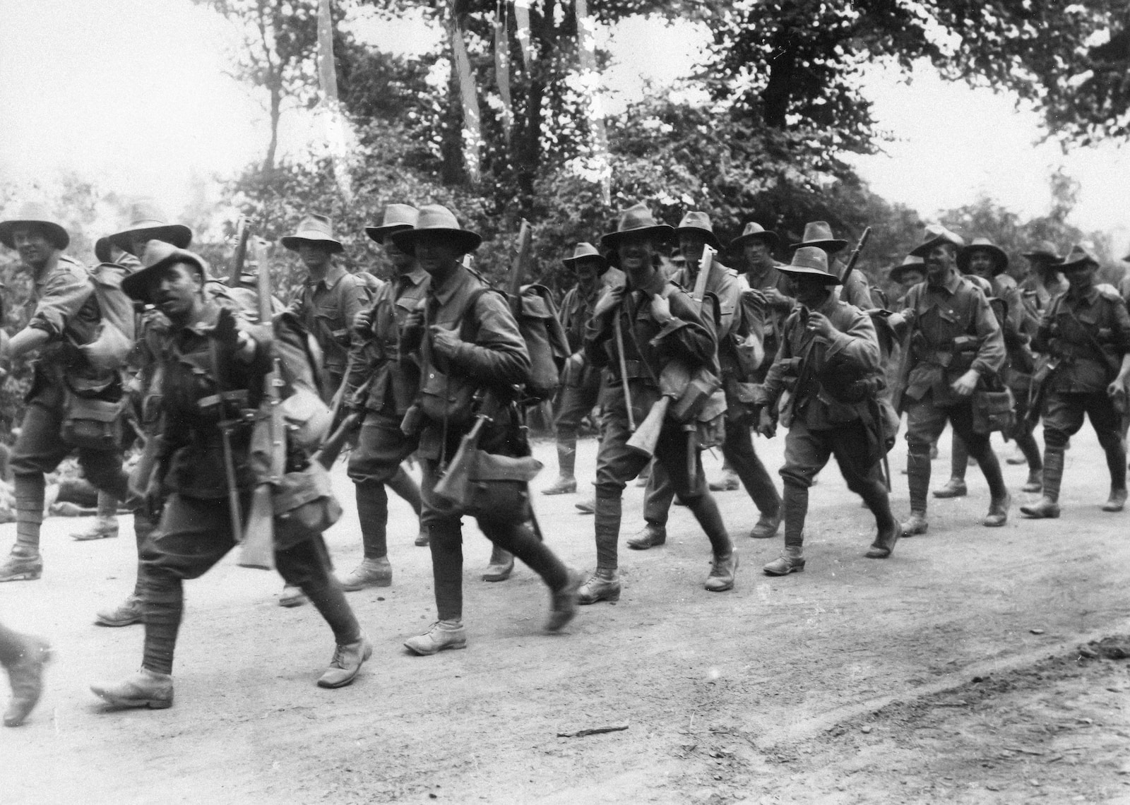 a group of soldiers walking down a dirt road
