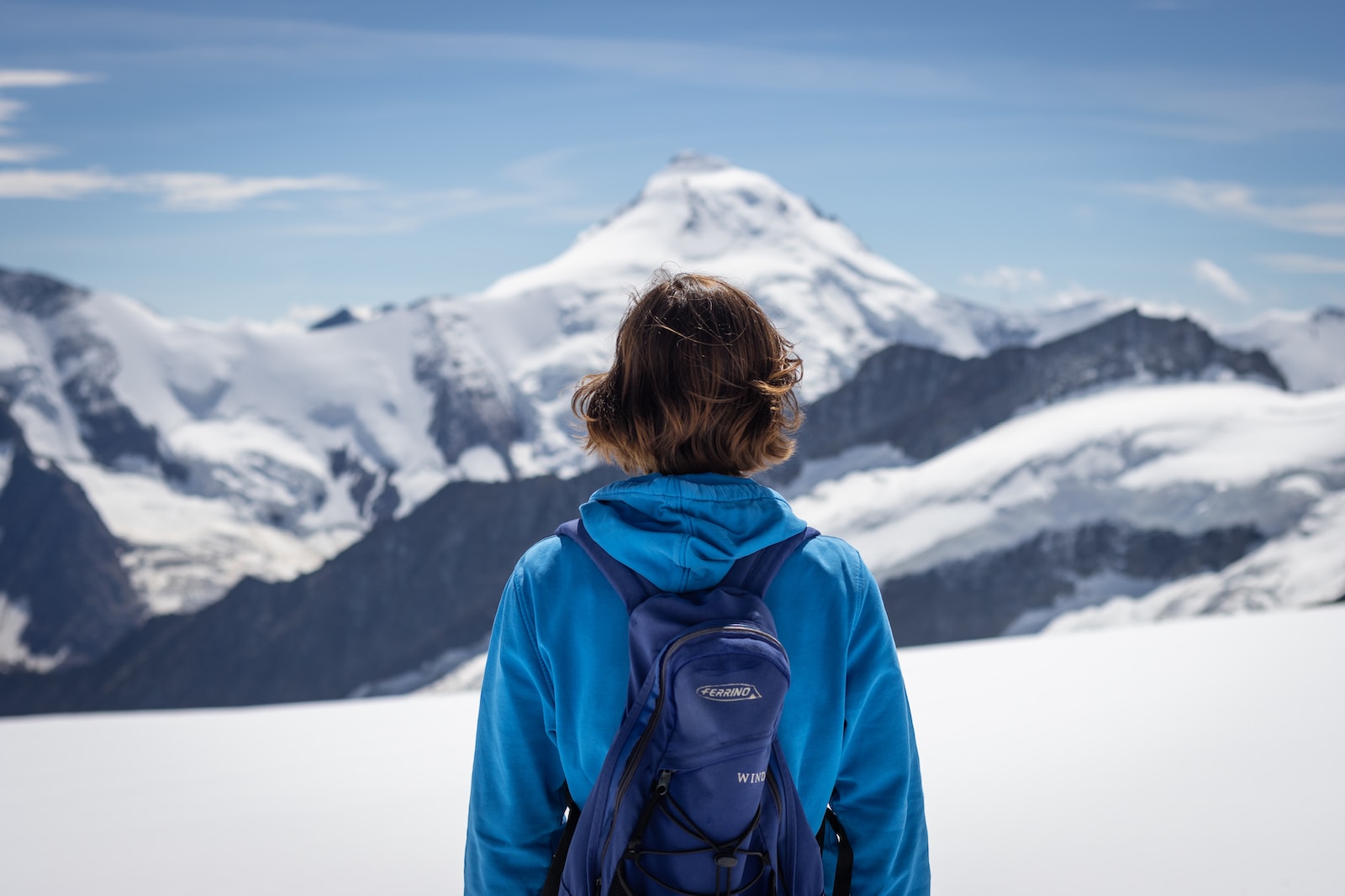 Mount Eiger woman in blue jacket looking at snow covered mountain during daytime