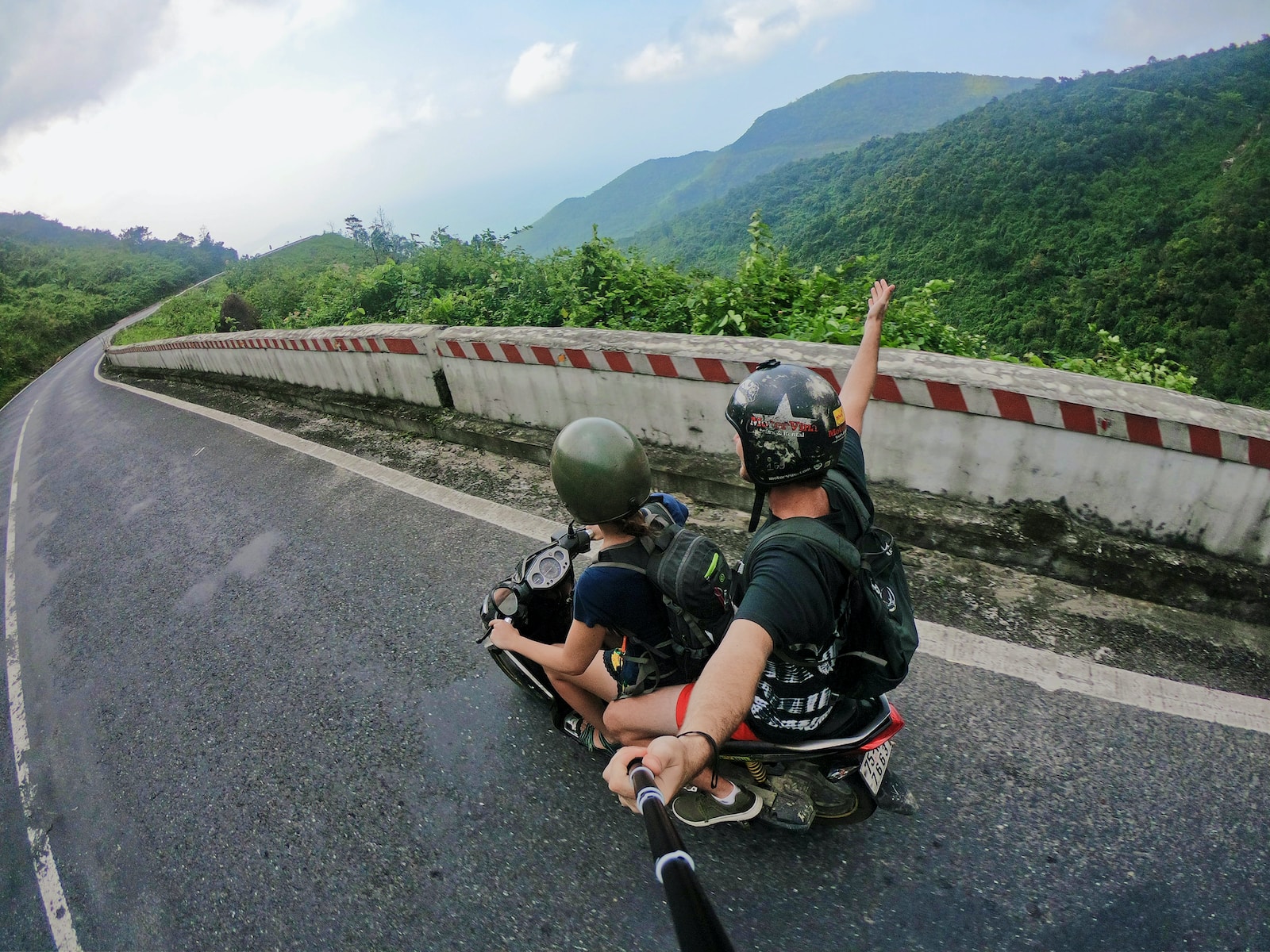 GoPro fish eye photography on woman riding motor scooter with man on bridge