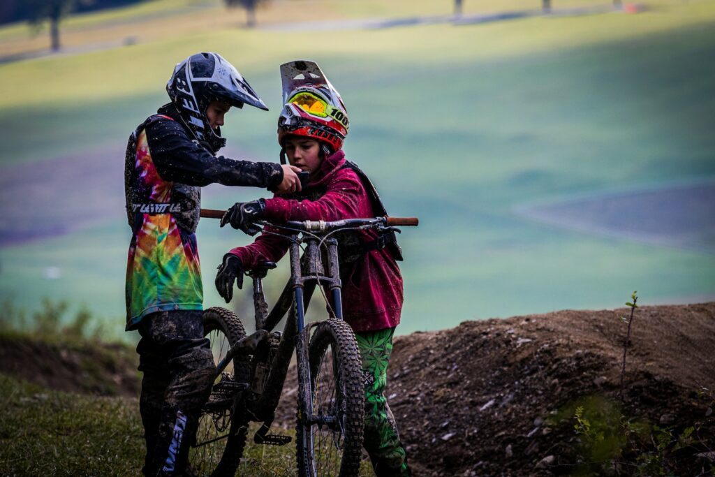 helmet camera man in black jacket riding on black and red mountain bike