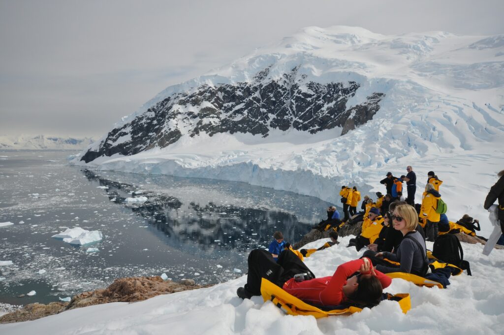 people on snow toward body of water