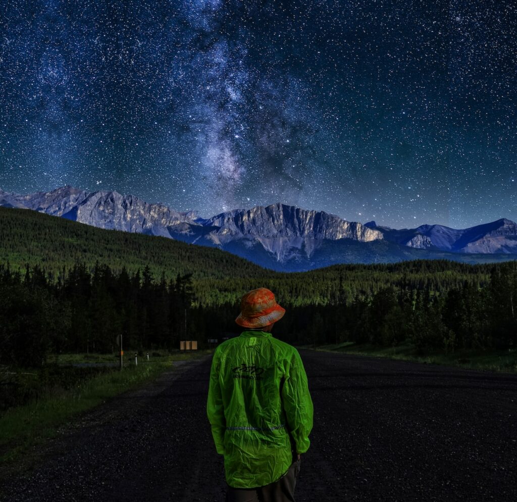 person wearing green sweater standing near the house during nighttime illustration