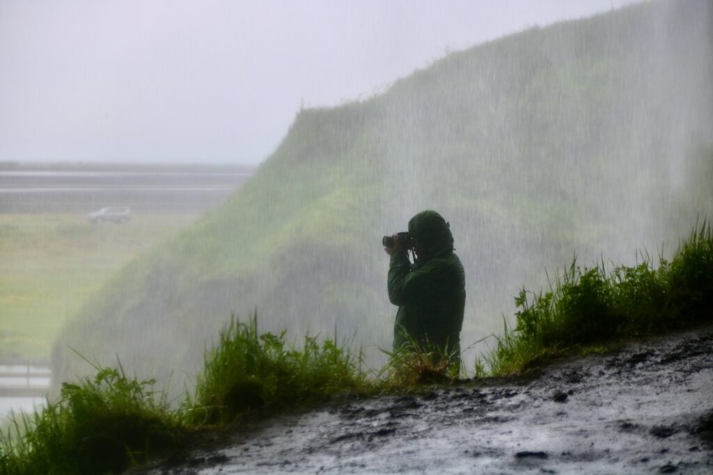 a person taking a picture of a waterfall